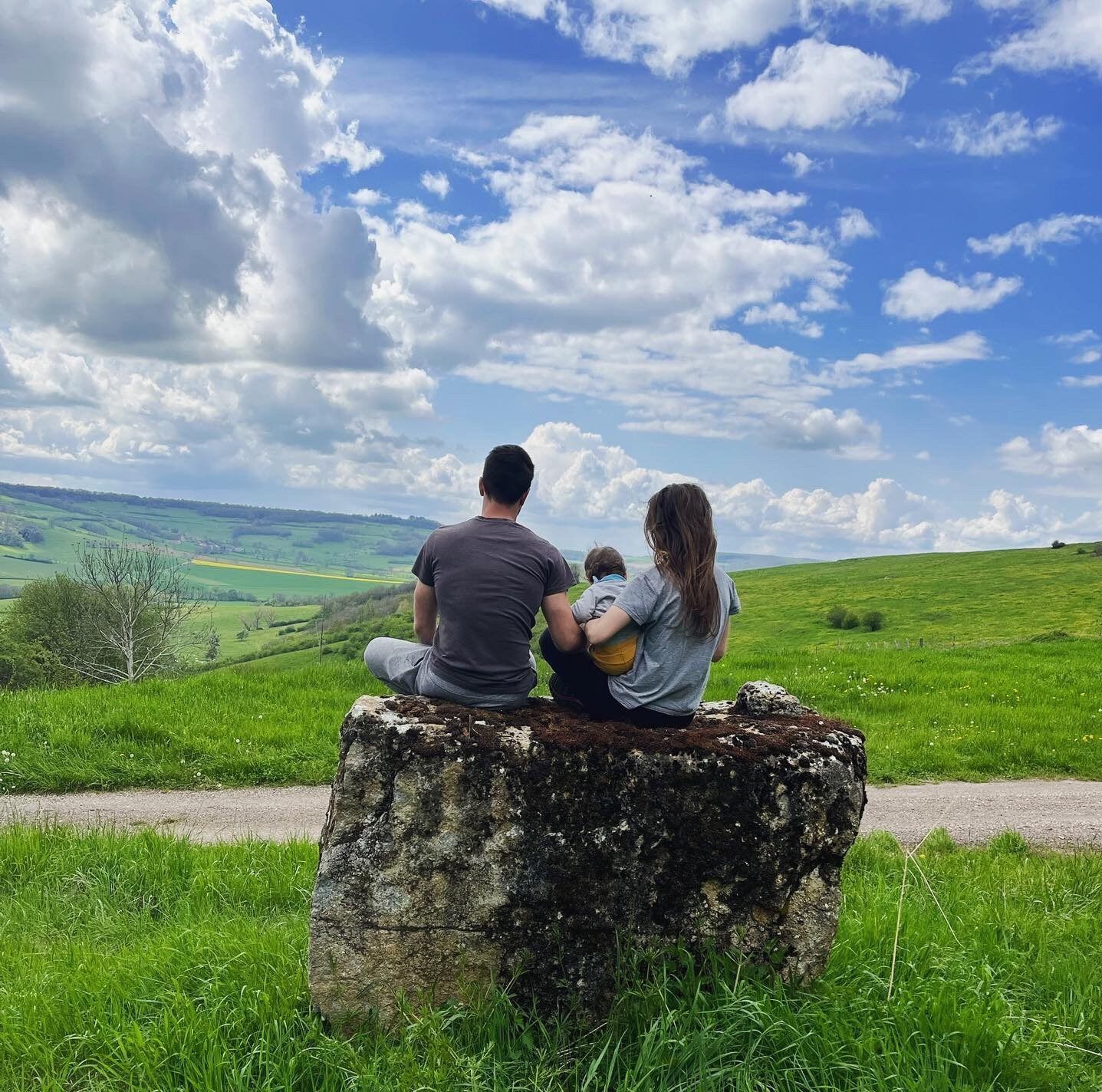Un couple assis sur un rocher face à la campagne bourguignonne
