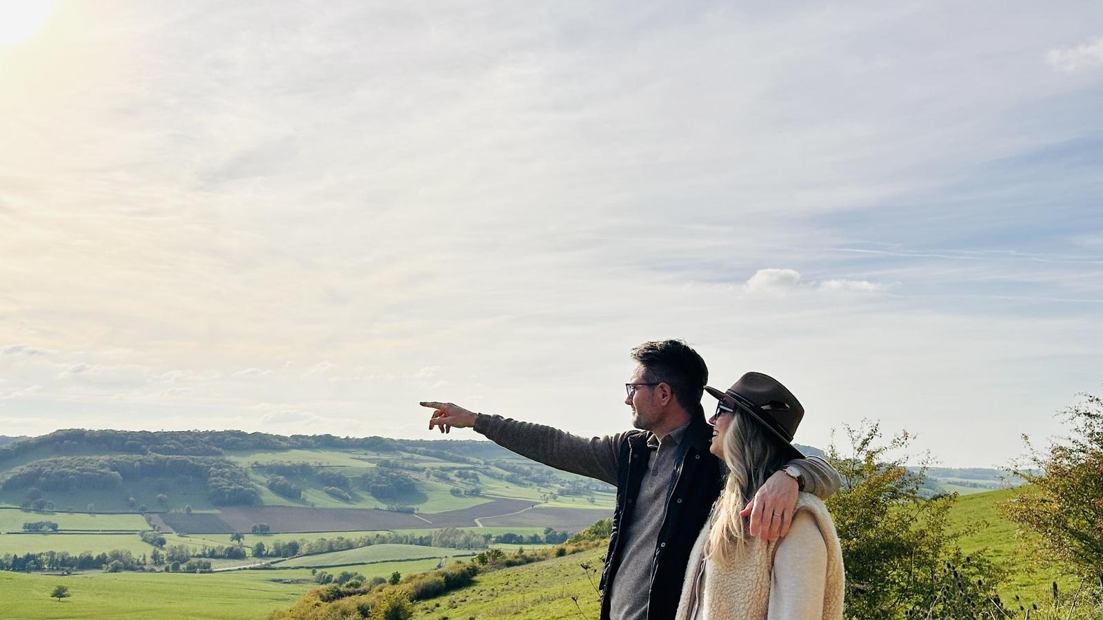 Un couple face à la vallée de l'Auxois, lui montrant l'horizon du doigt