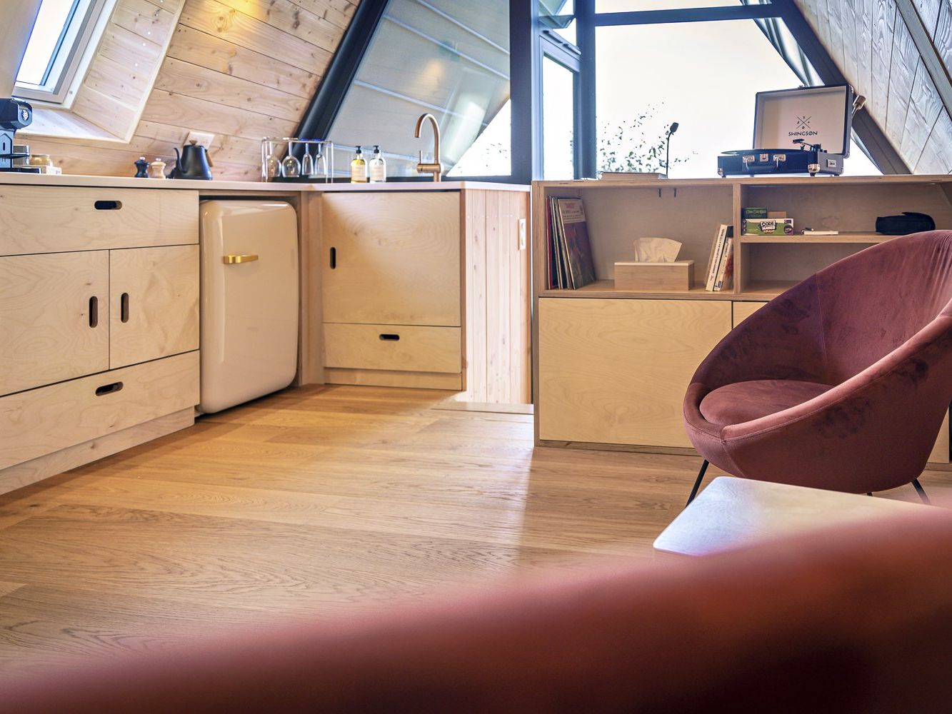 Cuisine en bois et fauteuil terracotta dans l'écolodge Etno