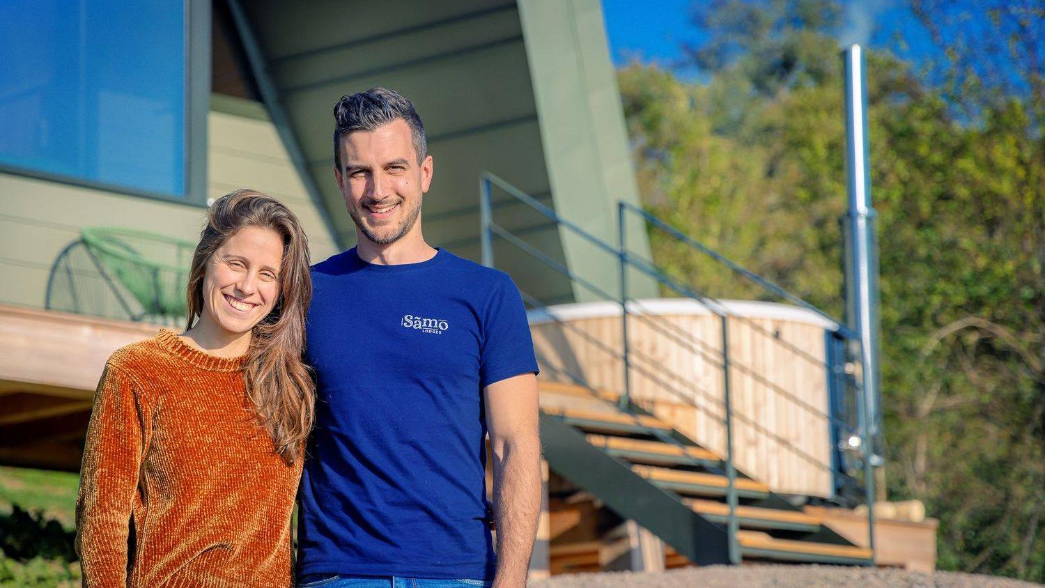 Morgane et Aurélien, fondateurs de Sãmo Lodges, devant un lodge et son bain nordique