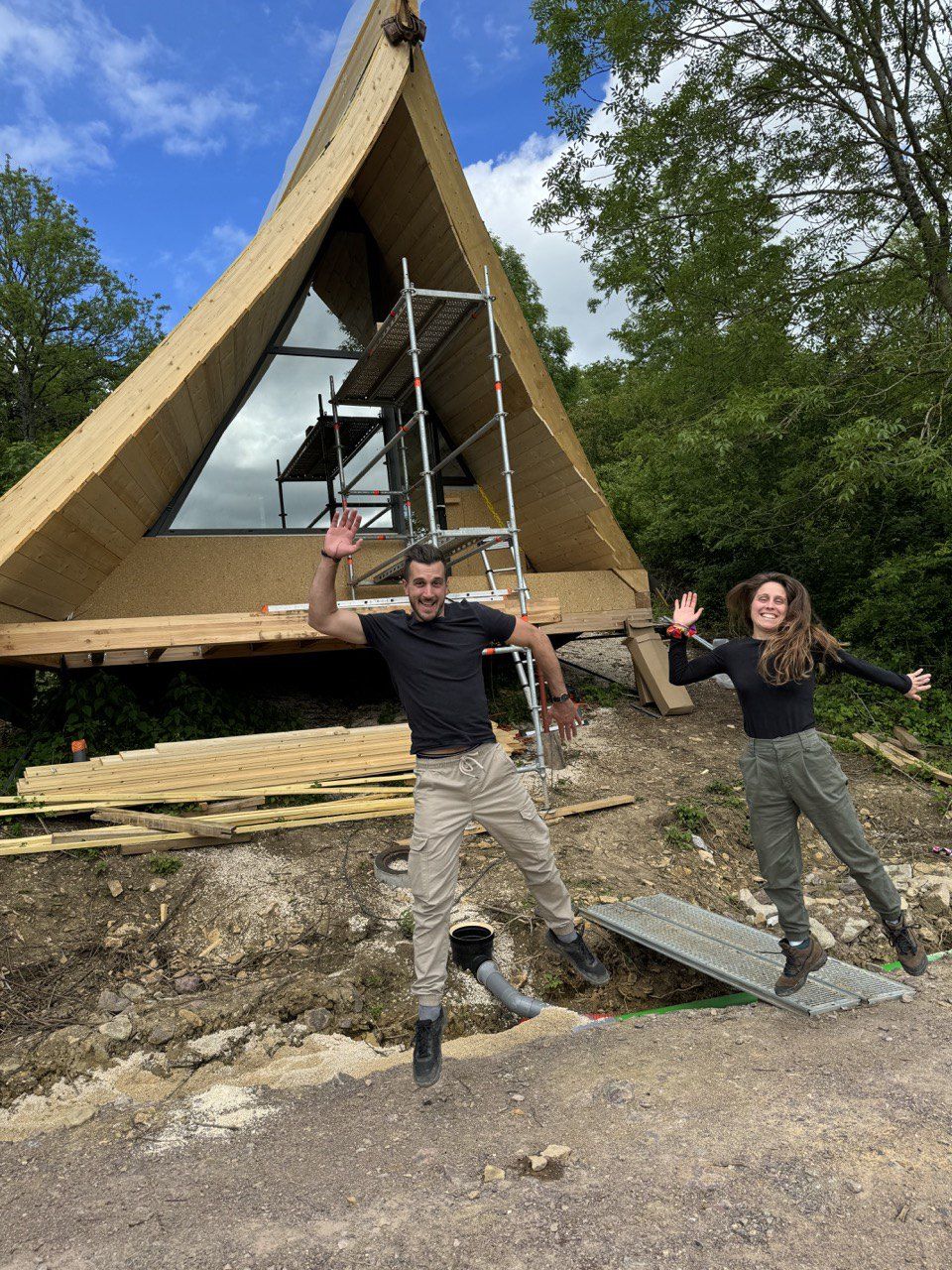 Morgane et Aurélien sautent de joie devant un lodge en A encore en chantier