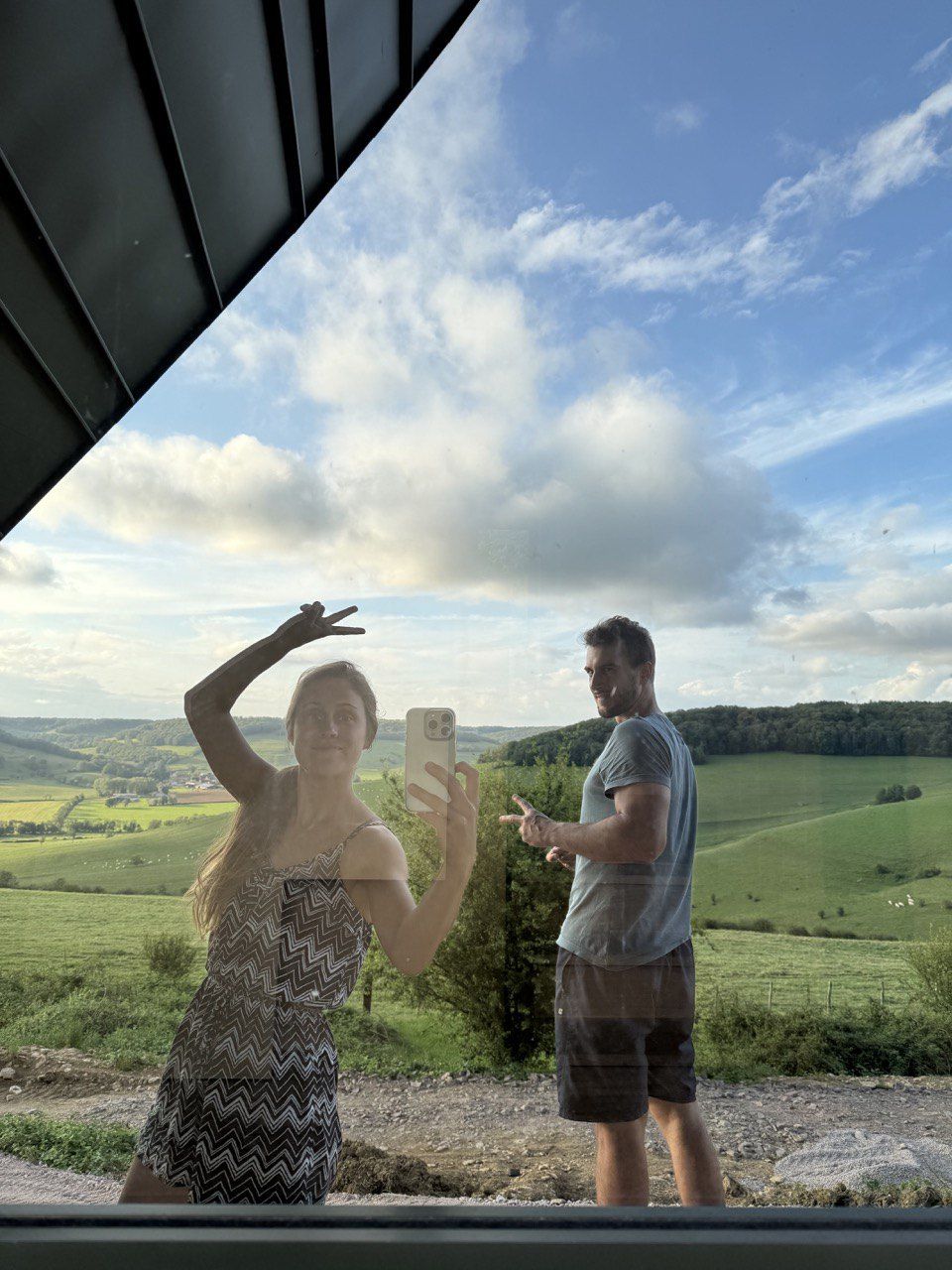 Un couple sur la terrasse d’un lodge terminé, face à la campagne