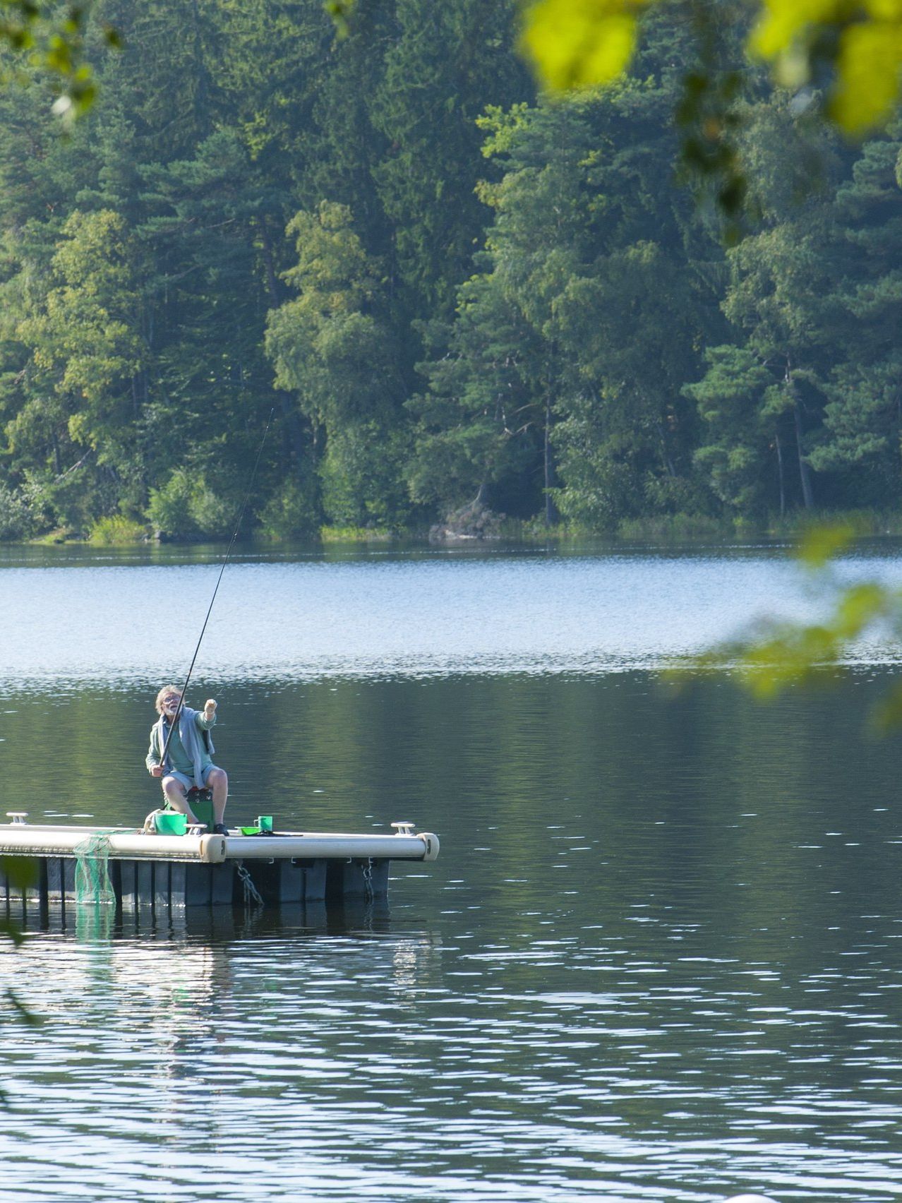 Lac paisible avec un ponton en bois et un pêcheur