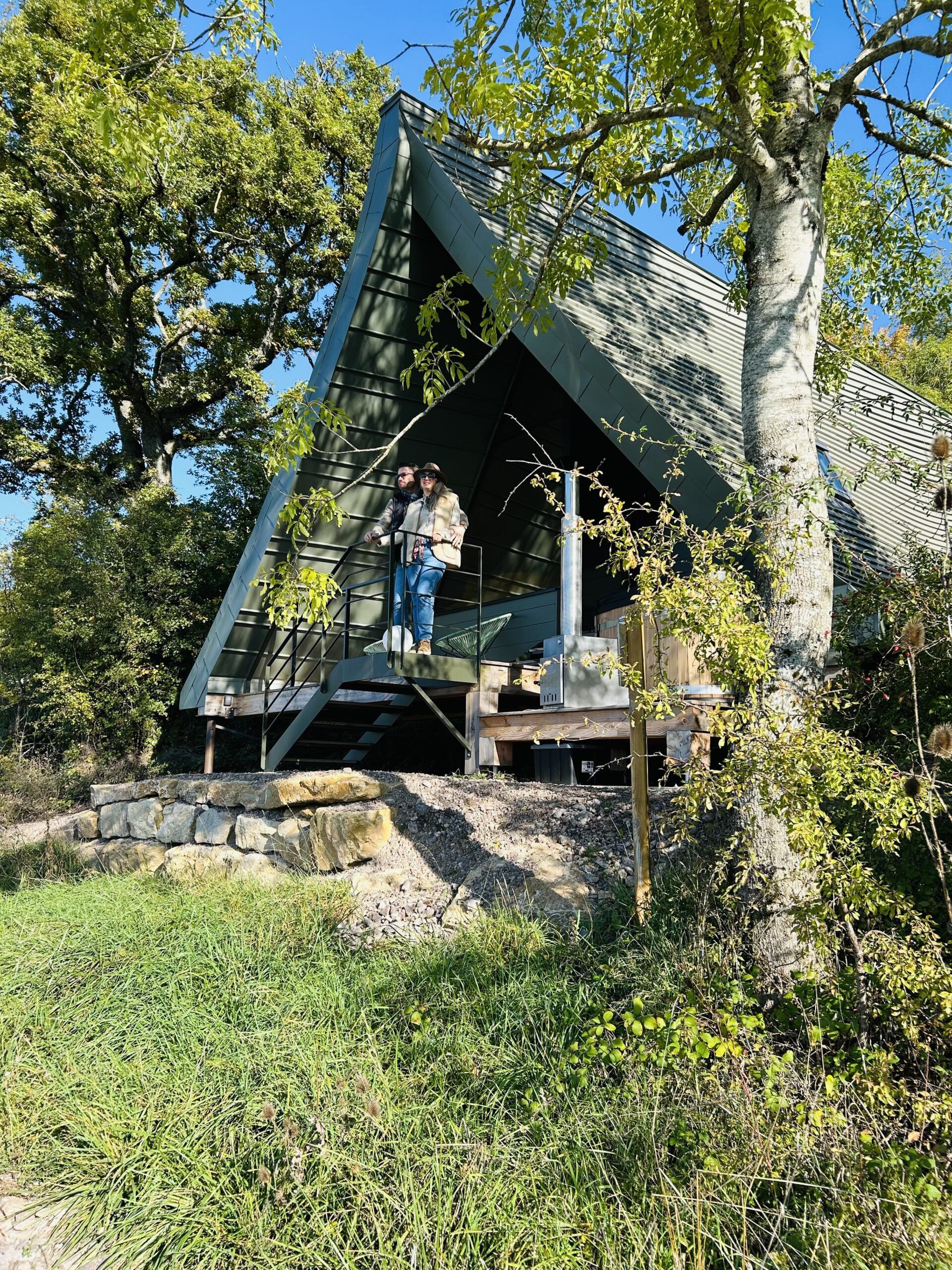 Un lodge en A et sa terrasse au milieu des arbres