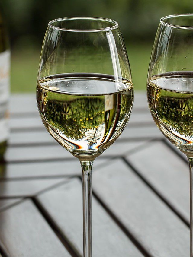 Deux verres de vin blanc et une bouteille sur une terrasse
